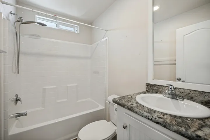 White vanity with beadboard paneling, granite-style countertop, and drop-in oval sink