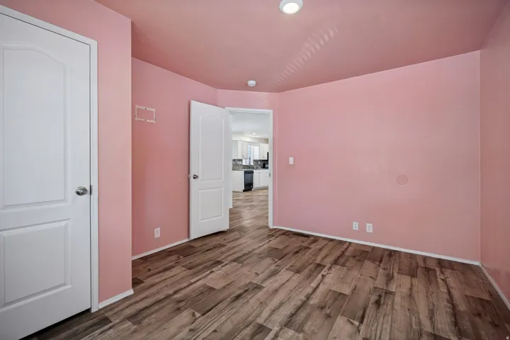 Wood-finish flooring throughout, white interior doors, and recessed ceiling lighting