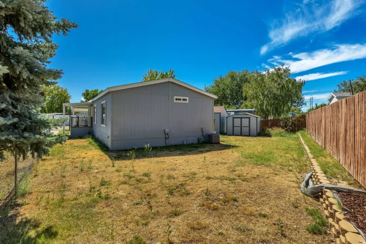 Exterior featuring a back deck, storage shed, and wood fencing