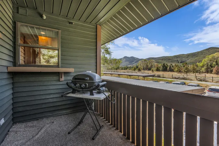 Balcony with textured flooring, dark wood-finish siding, and mountain scenery