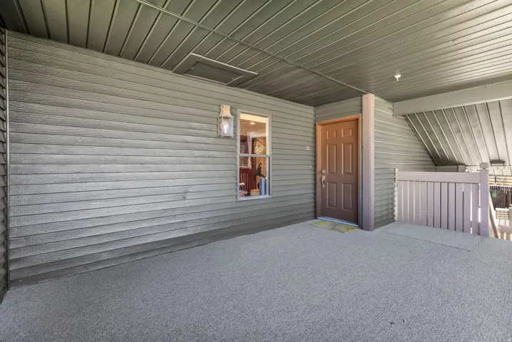 Covered exterior entry with textured siding