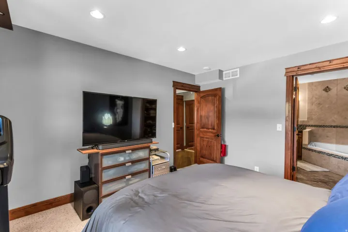 Recessed lighting, wood-finish trim, wood-panel doors, and carpet flooring