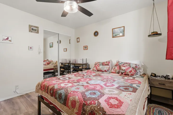 Bedroom #2  Featuring wood-style LVP flooring, ceiling fan with integrated lighting, and mirrored closet doors