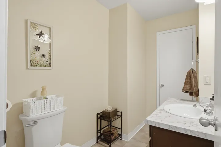 Half bath upstairs. White vanity with an integrated sink and a stone-look countertop