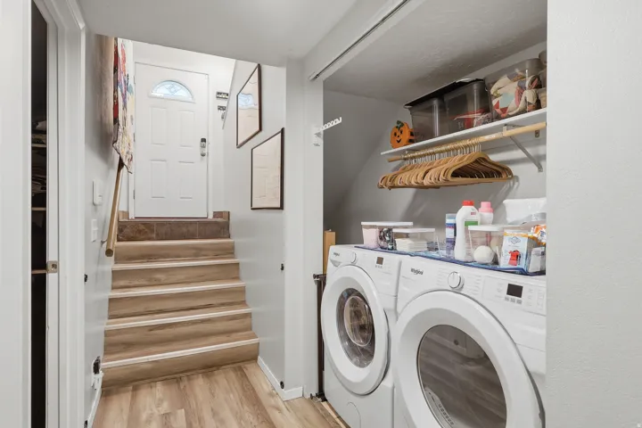Laundry area with built-in shelving, wood-finish LVP flooring.