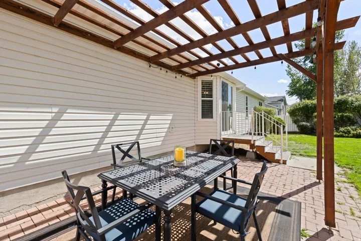Expansive patio with brick pavers and a wood pergola