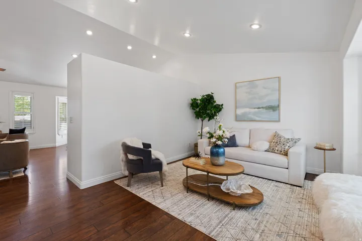Recessed lighting illuminates the space, featuring wood-finish flooring and white walls