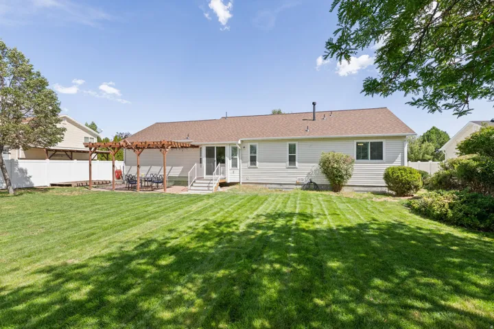 Expansive green lawn with mature trees and a dedicated patio space