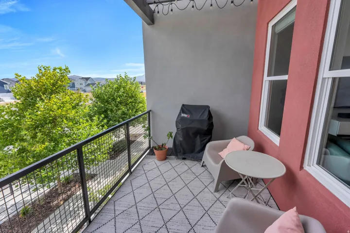 Outdoor balcony featuring a black metal railing and red exterior walls