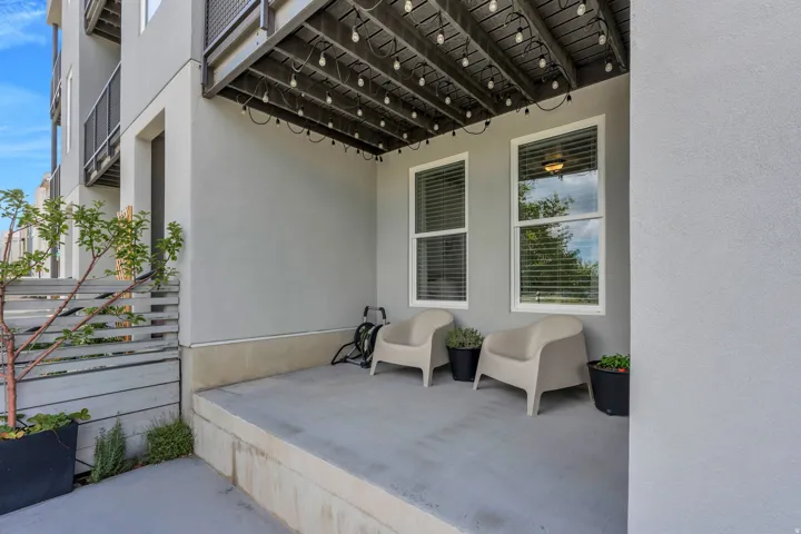 Covered patio with string lighting and multiple windows