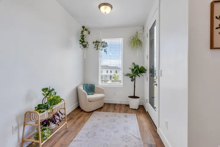 Wood-finish flooring, white walls, and a window with horizontal blinds