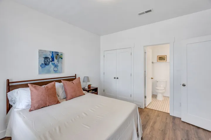 Wood-finish flooring, white walls, and a built-in closet with double doors