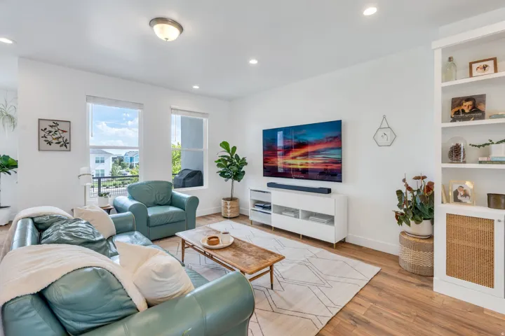 Recessed lighting, wood-finish flooring, built-in shelving, white walls, and multiple windows