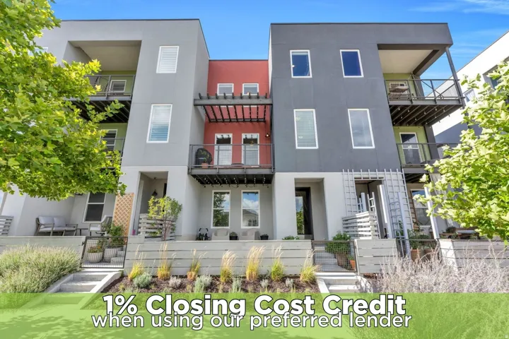 Modern multi-story facade with balconies, multi-pane windows, and a landscaped front entry