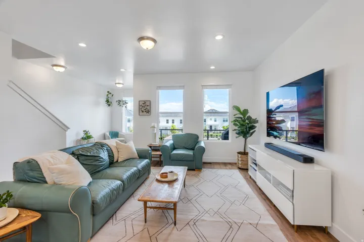 Bright living area with recessed lighting and wood-finish flooring