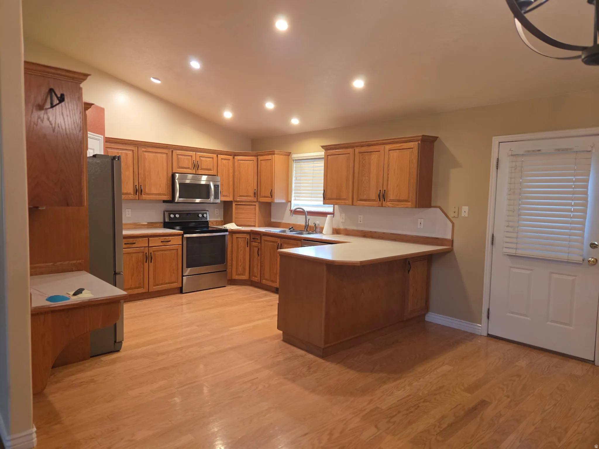Kitchen featuring wood-finish cabinetry, stainless steel appliances, and recessed lighting