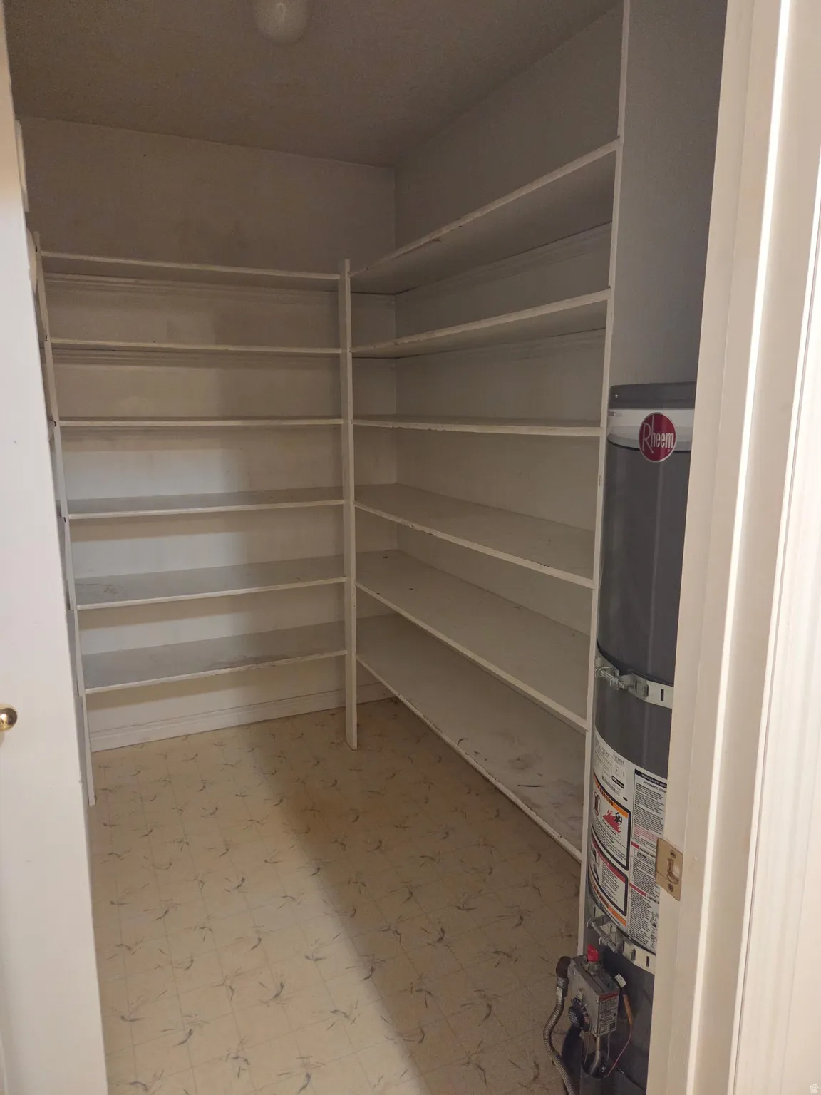 Built-in shelving with multiple levels, overhead lighting, and patterned flooring