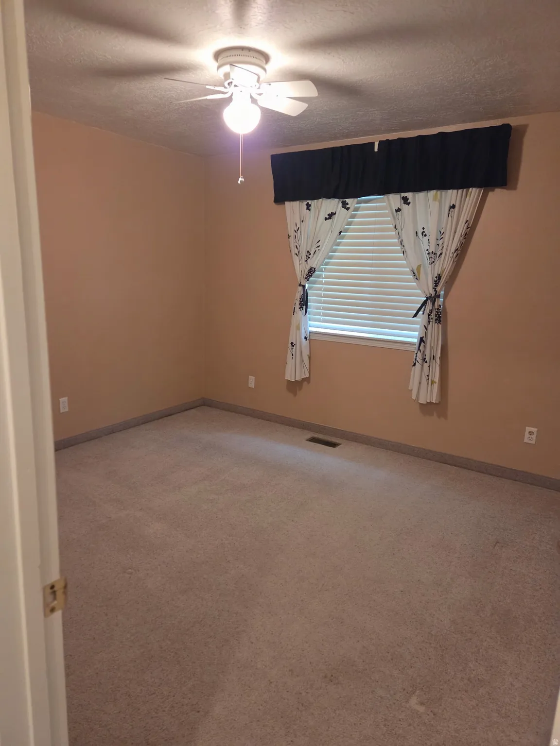 Carpeted flooring, ceiling fan with illumination, and a window with blinds