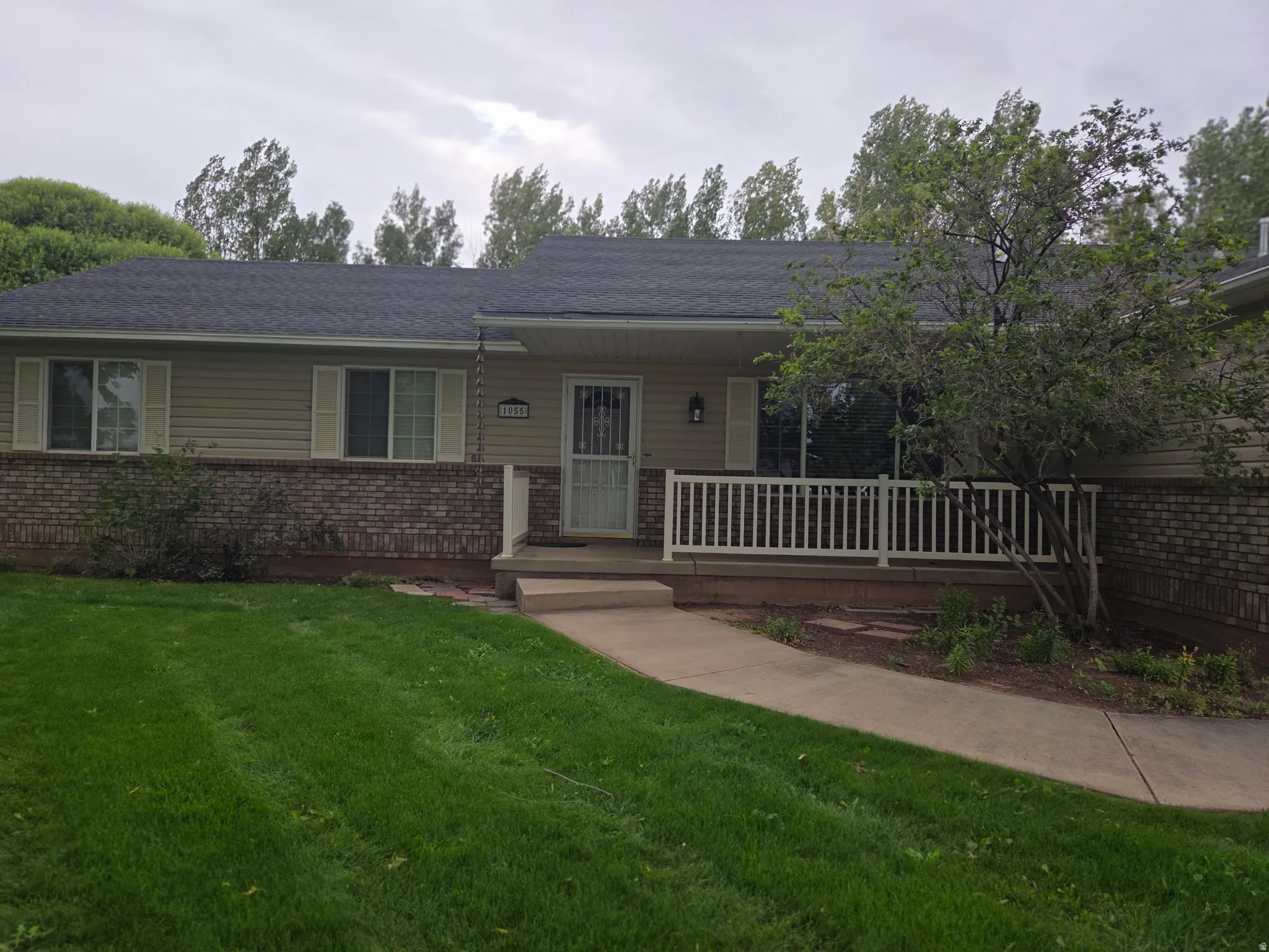 Light-toned siding exterior with a dark shingle roof