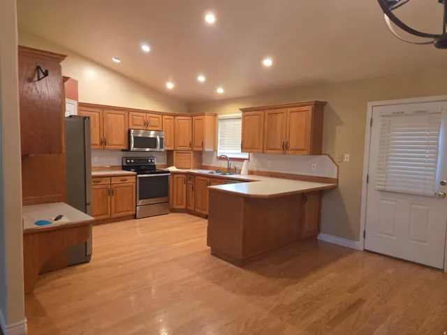 Kitchen featuring wood-finish cabinetry, stainless steel appliances, and recessed lighting