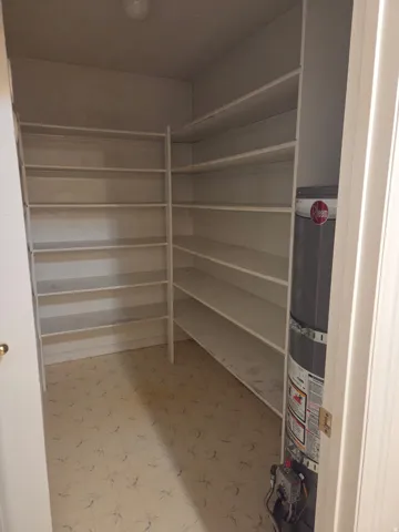 Built-in shelving with multiple levels, overhead lighting, and patterned flooring