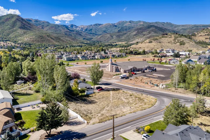 Expansive mountain backdrop with scattered residential structures and mature trees