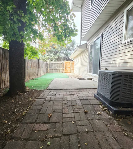 Brick paver pathway with a concrete patio