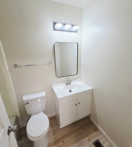 White vanity with a single basin sink, chrome faucet, and rectangular mirror