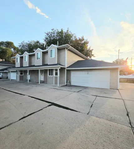 Multi-unit dwelling with light-colored siding and dormer windows