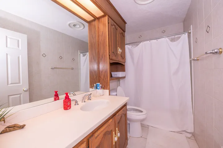 Bathroom featuring a vanity with a single basin sink, wood cabinetry, and a full-width mirror