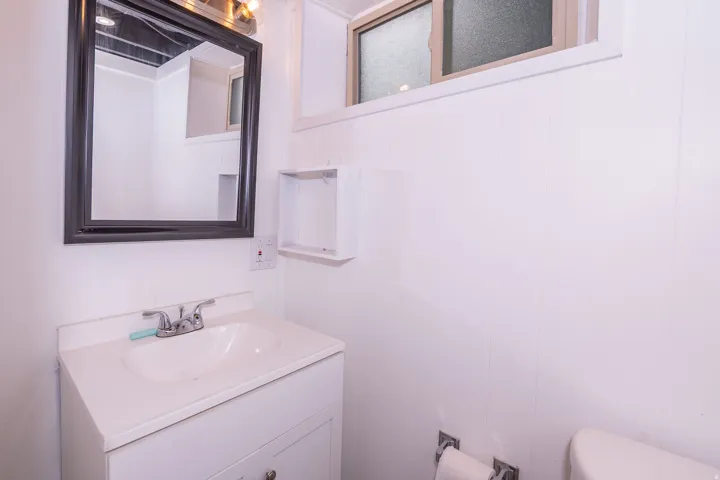 White vanity with integrated sink and chrome faucet