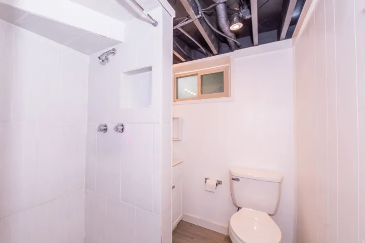 Shower with white tile surround, built-in niche, and chrome fixtures