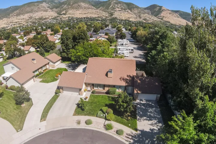 Property with a brown shingle roof, attached two-car garage, and a lush green lawn
