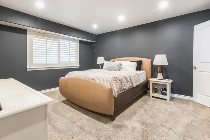 Recessed lighting, window with plantation shutters, broadloom carpet, painted walls, and a paneled interior door