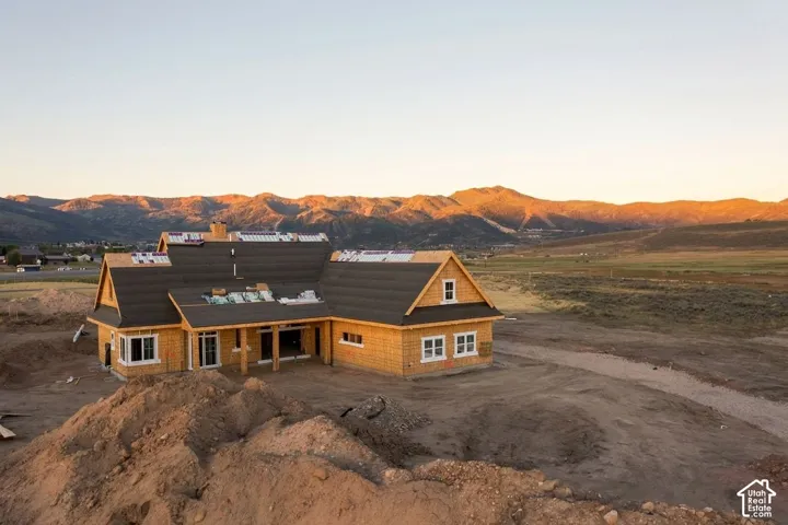 New construction property featuring a timber-frame structure, multi-gabled roofline, and mountain backdrop