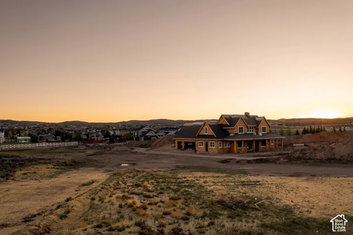 Multi-gabled residential structure featuring wood-frame construction, a covered front porch, and a dark shingle roof, set within a vast landscape