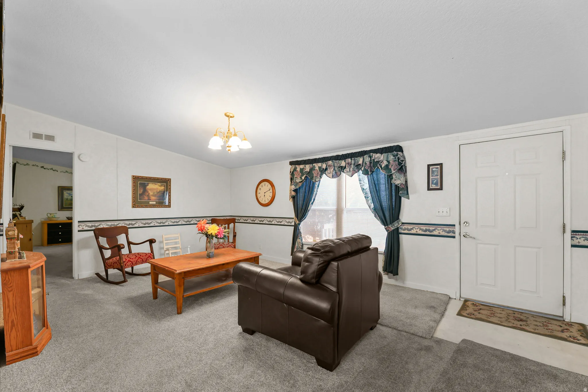 Light gray carpeting throughout, white paneled walls, and a multi-bulb ceiling fixture