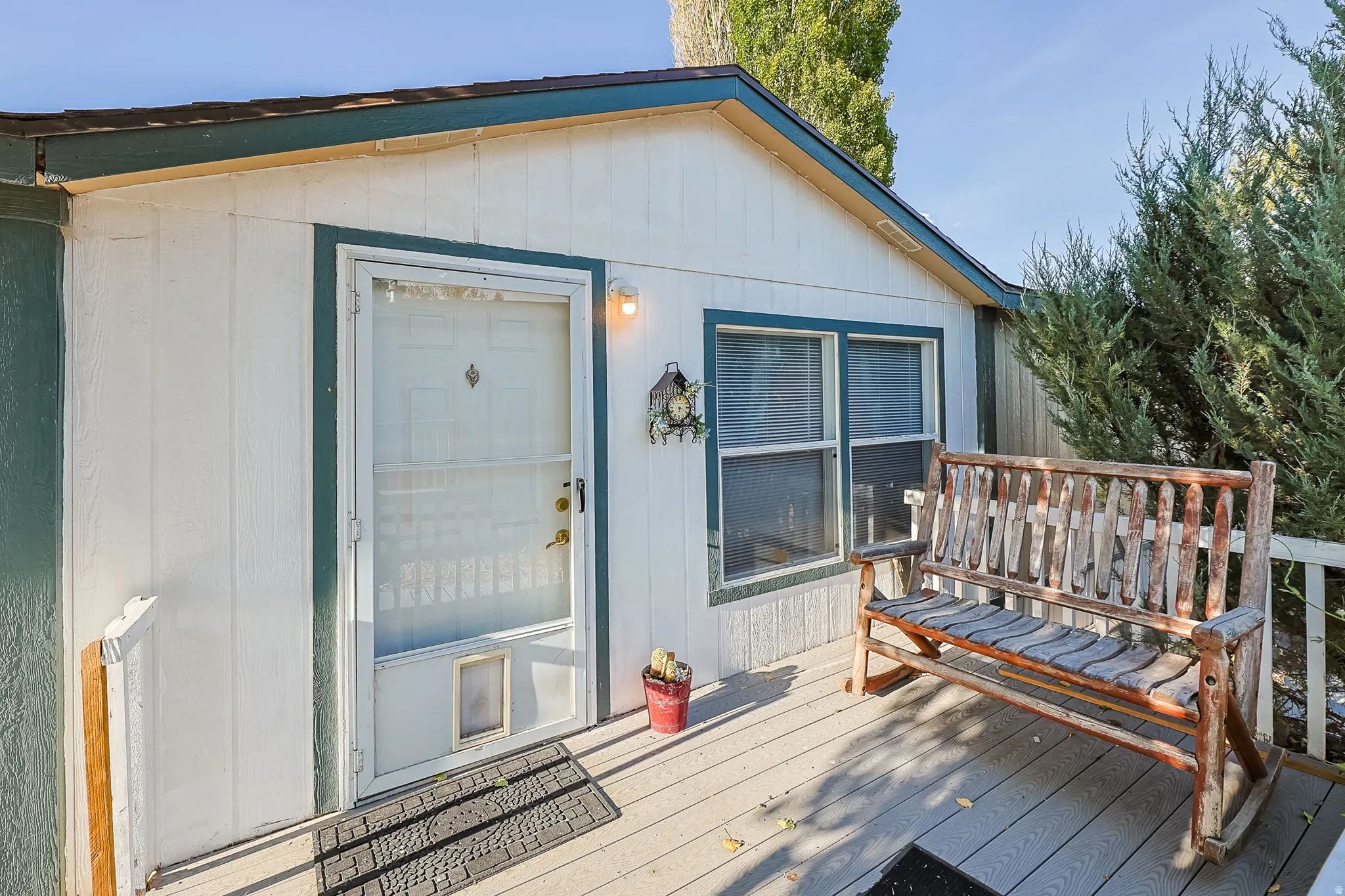 White siding exterior with a contrasting dark green trim