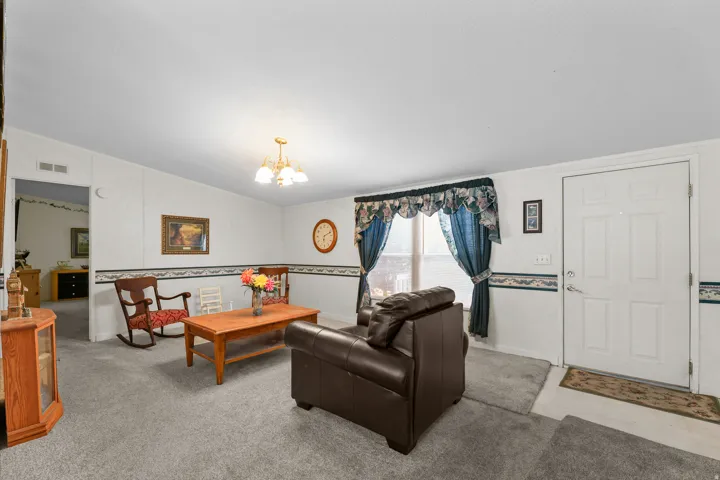 Light gray carpeting throughout, white paneled walls, and a multi-bulb ceiling fixture
