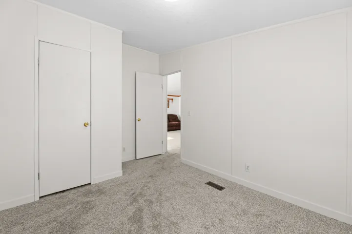 Neutral wall finishes, recessed lighting, wall-to-wall carpeting, and white trim accents