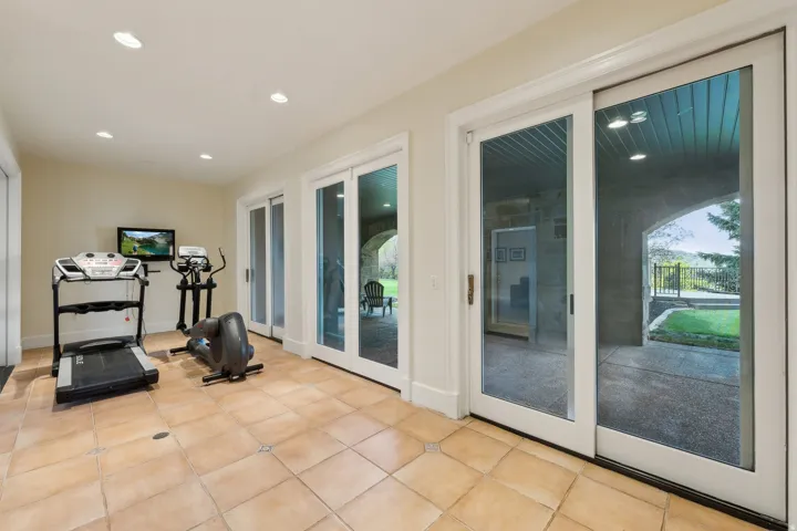 Recessed lighting, tile flooring, and multiple sets of sliding glass doors