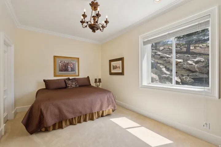 Traditional chandelier lighting, recessed ceiling lighting, crown molding, white trim, and a window with a rock garden backdrop