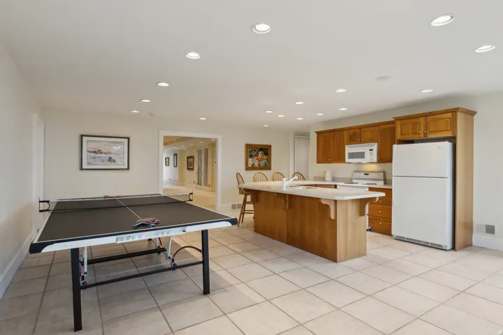 Recessed lighting illuminates an open-concept space featuring tile flooring