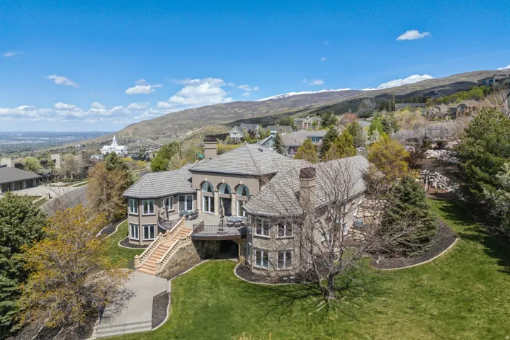 Expansive property featuring a multi-level design, stone facade, and a large elevated deck