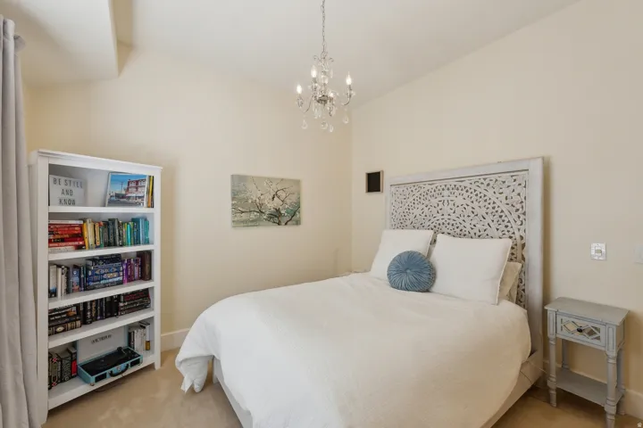 Neutral wall finishes, recessed lighting, and a decorative chandelier