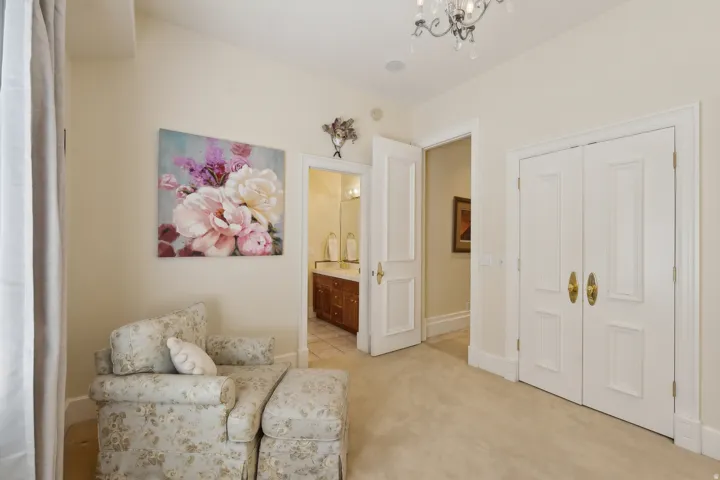 Recessed ceiling lighting, chandelier, paneled double doors with brass hardware, and a single paneled door with brass hardware