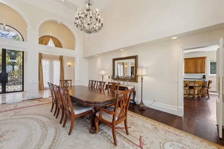 Two-story entry with ornate wrought iron double doors and arched transom