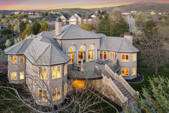 Multi-level property with an expansive outdoor patio, grand exterior staircase, and multiple arched windows
