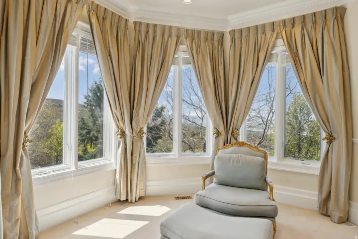Bay window with multiple glass panels, crown molding, and neutral-toned wall-to-wall carpeting
