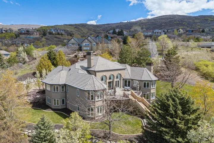 Multi-level residence featuring a tiered tile roof, arched windows, and multiple outdoor deck spaces